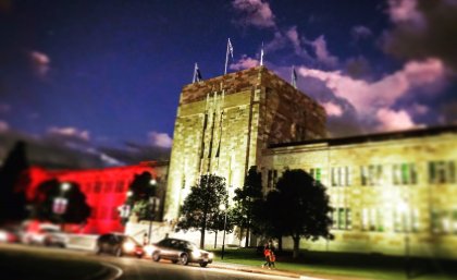 UQ's Forgan Smith building lit in Aboriginal flag colours.