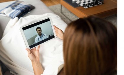 Woman staring at screen with doctor on it