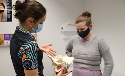 Image: Metro North Health Two people wearing face masks looking at an anatomical model