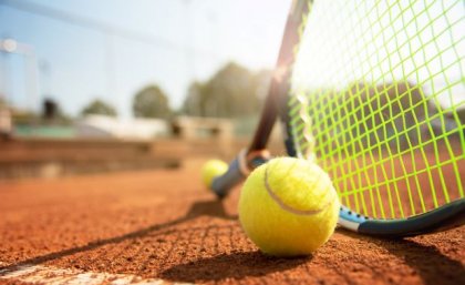 Image: Adobe A low angle view of a tennis court, tennis racquet and ball