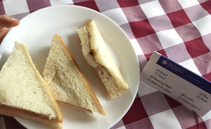 Many centres frequently provided low nutrition foods, including savoury spread sandwiches on white bread. A plate of white, triangular sandwiches on a table with a red and white checkered table cloth