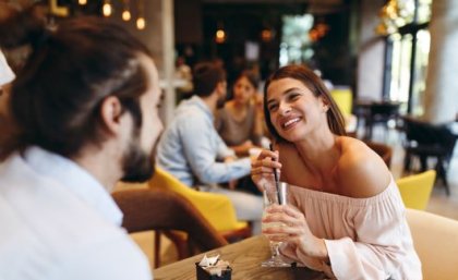 Image: Adobe A man and a woman on a date, the woman holding a drink