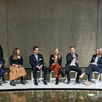 A panel of 6 people sitting at the front of a room